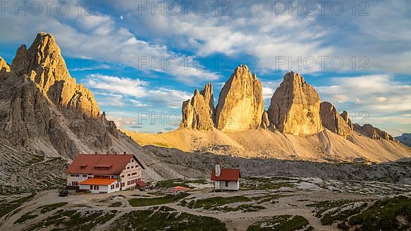 View of mountain hut Dreizinnenhuette and chapel with rock massif Paternkofel and mountain range drei Zinnen, panorama