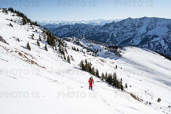 Ski tourers on ski tour on the Rotwand, behind mountain hut Rotwandhaus with mountain panorama
