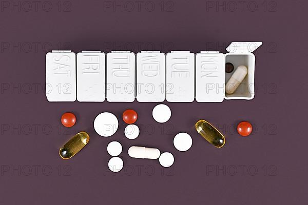 Pill box with many different medical pills and casuals,