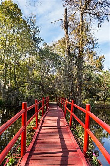 Red bridge over a pond in the Magnolia Plantation outside Charleston, South Carolina