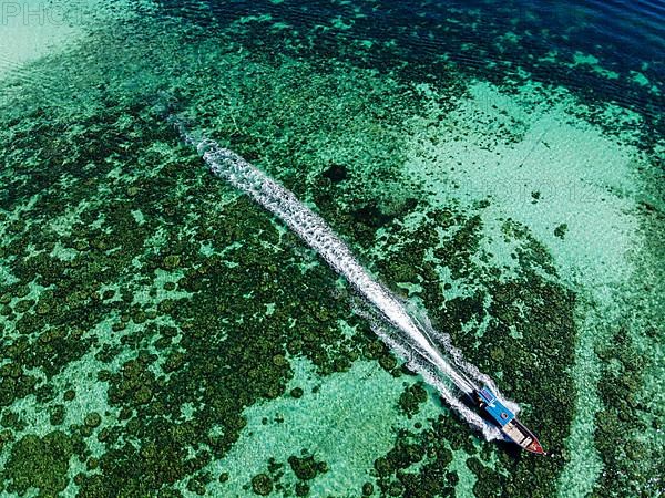 Aerial from a fishing boat gliding through the pristine waters of Koh Lipe, Tarutao National Park