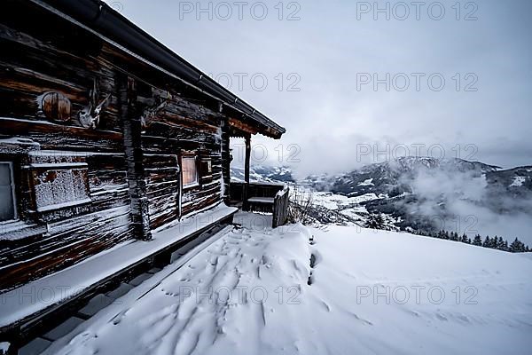 Snowfall, mountain hut in the snow