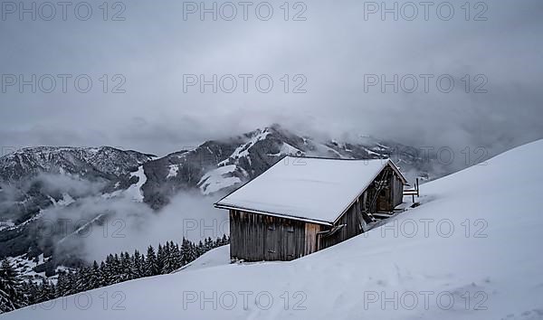 Snowfall, mountain hut in the snow