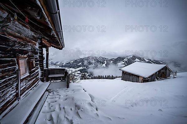 Snowfall, mountain hut in the snow
