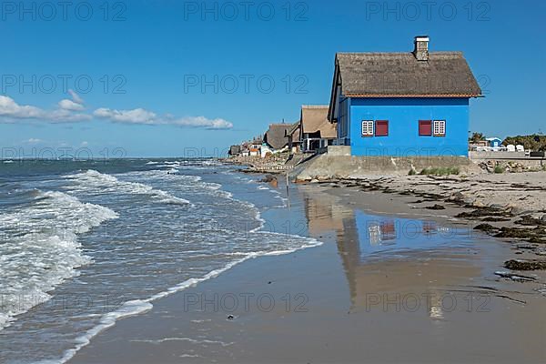 Thatched roof houses on the beach, Fehmarnsund Bridge