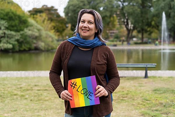 Love. Cheerful queer woman holding a message supporting the LGBT community,