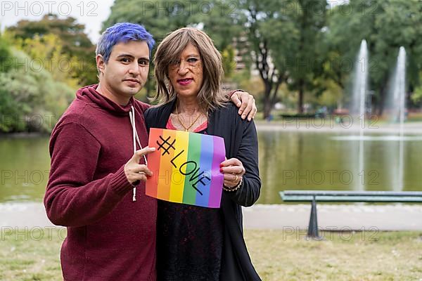 Love. Cheerful queer couple holding a message supporting the LGBT community,