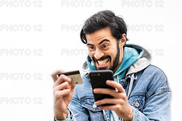 Latin man using credit card to make online payment on smartphone. mixed-race man using cellphone for shopping online. Guy using smart phone to check credit card transactions from app. White background,