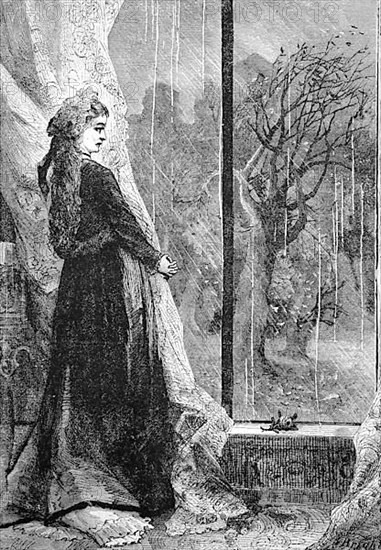 Rainy day, woman standing in front of a large window looking into the rainy landscape