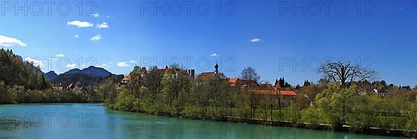 The Lech near Fuessen with a view of the Benedictine monastery of St. Mang and high castle. Ostallgaeu Swabia, Bavaria