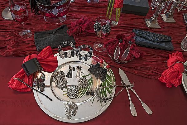 Rhinestone jewellery and accessories decorated on a silver plate and red cloth, Bavaria