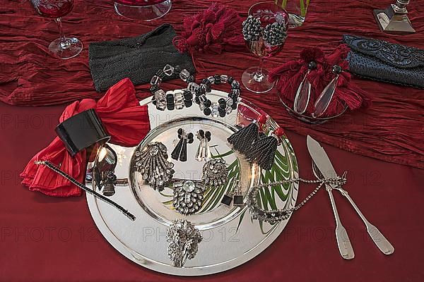 Rhinestone jewellery and accessories decorated on a silver plate and red cloth, Bavaria