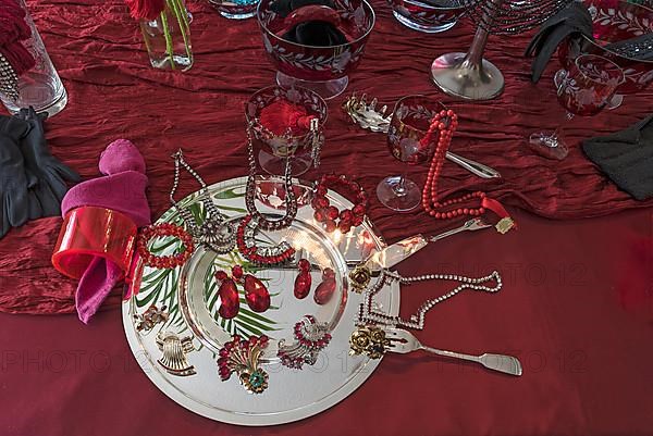 Rhinestone jewellery and accessories decorated on a silver plate and red cloth, Bavaria