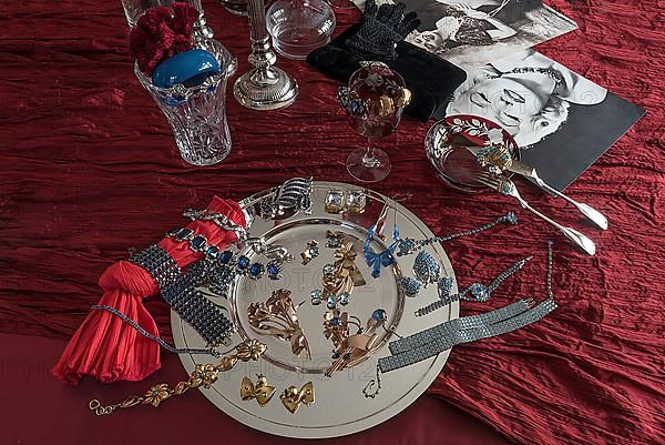 Rhinestone jewellery and accessories decorated on a silver plate and red cloth, Bavaria