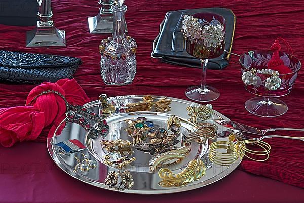 Rhinestone jewellery and accessories decorated on a silver plate and red cloth, Bavaria