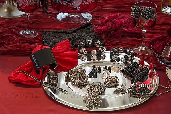 Rhinestone jewellery and accessories decorated on a silver plate and red cloth, Bavaria