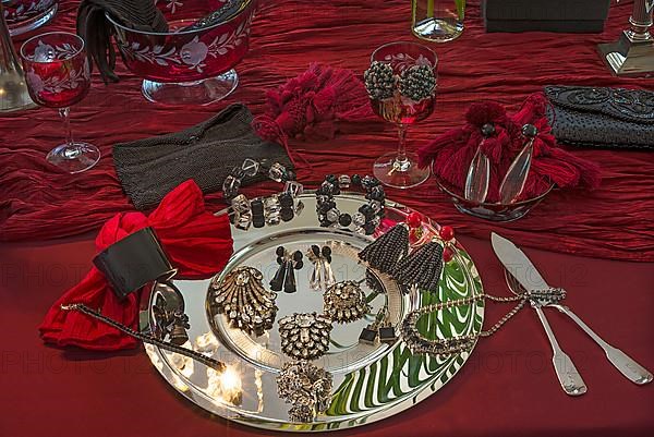 Rhinestone jewellery and accessories decorated on a silver plate and red cloth, Bavaria