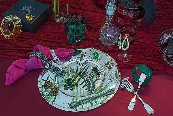 Rhinestone jewellery and accessories decorated on a silver plate and red cloth, Bavaria