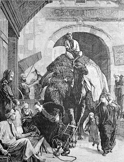 A street in cairo, a merchant with a loaded camel rides through the gate