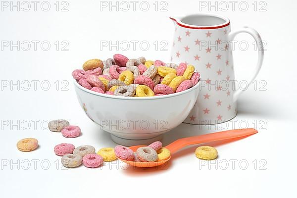 Fruit-flavoured cereal rings in bowl and spoon, children's breakfast