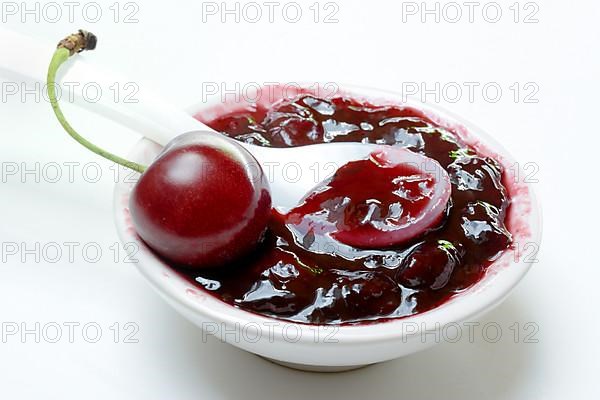 Cherry jam in small bowls and black wild cherry,
