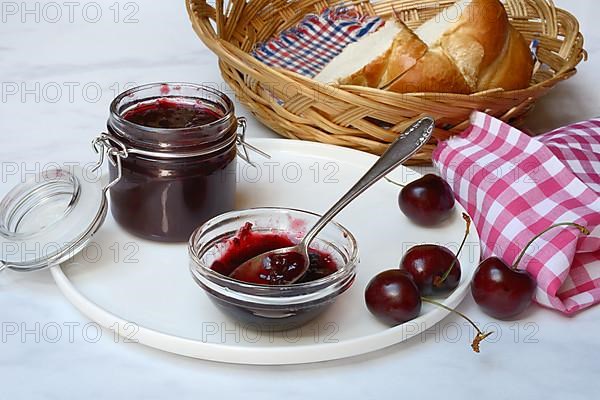 Cherry jam in small bowl with spoon, Black cherries