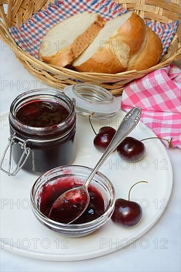 Cherry jam in small bowl with spoon, Black cherries