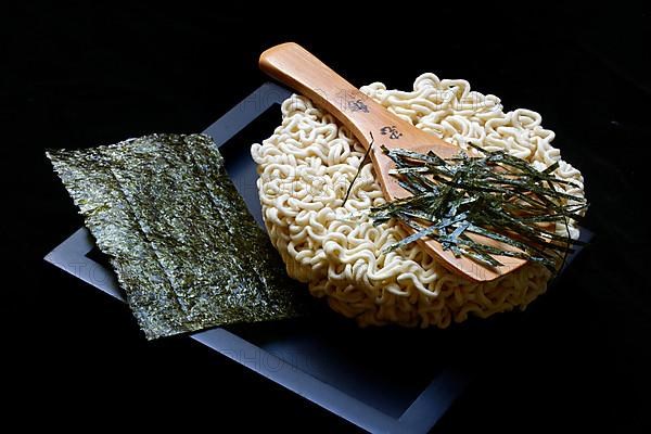 Nori, cut paper-like sheet of seaweed and Asian noodles with chopsticks