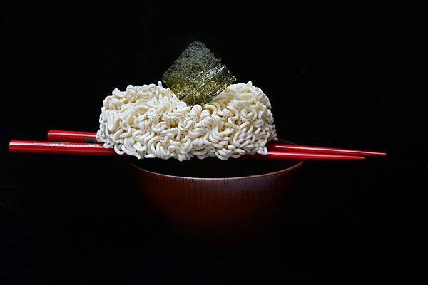 Nori, dried paper-like sheet of seaweed and Asian noodles on a shell