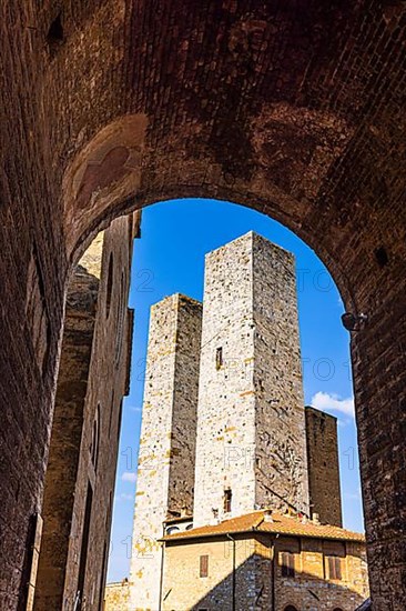 Gender towers and medieval archway against a blue sky, San Gimignano