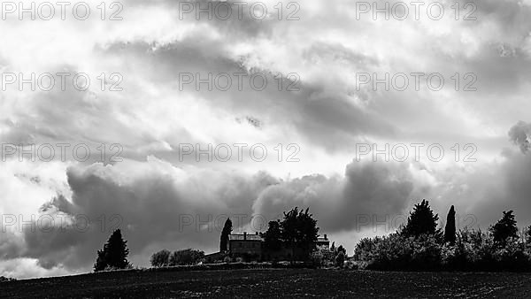 Dark clouds over a country house, black and white photograph