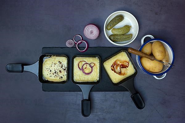 Raclette, melted raclette cheese in pans and ingredients