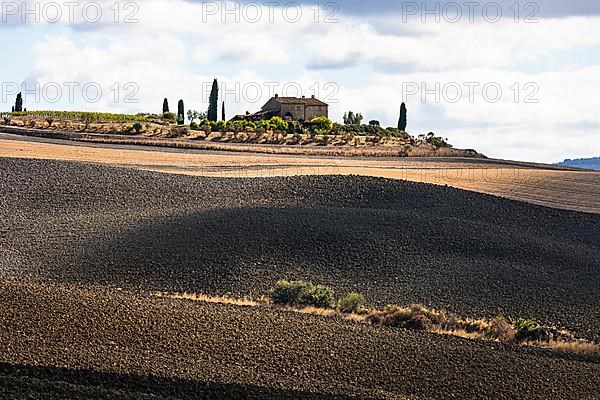 Country house on hill, ploughed field