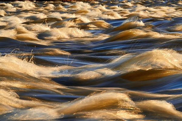 Rapids of the Zambezi River close up with the golden light of the African sunset, Photographed with long exposure to show movement
