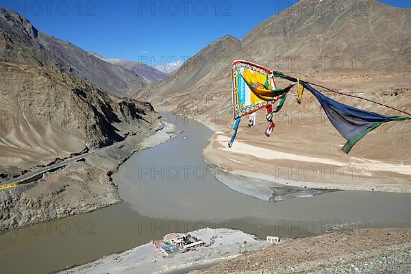 Confluence of the Indus and Zanskar rivers in the Himalayas, prayer flag in front