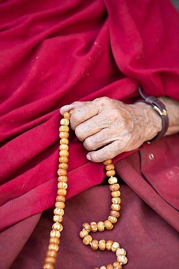 Monk holding prayer chain, Buddhist Yellow Cap Monastery Rizong or Rhizong or Yuma Changchubling