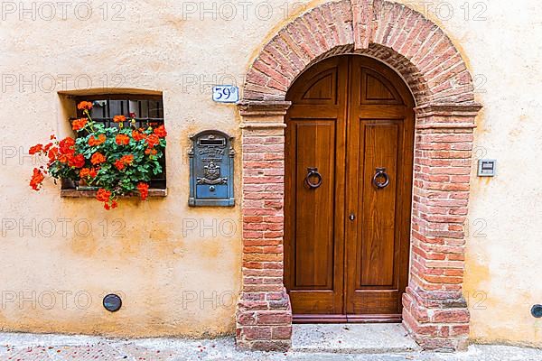 Round arch front door with flower window and decorative letterbox, Trequanda