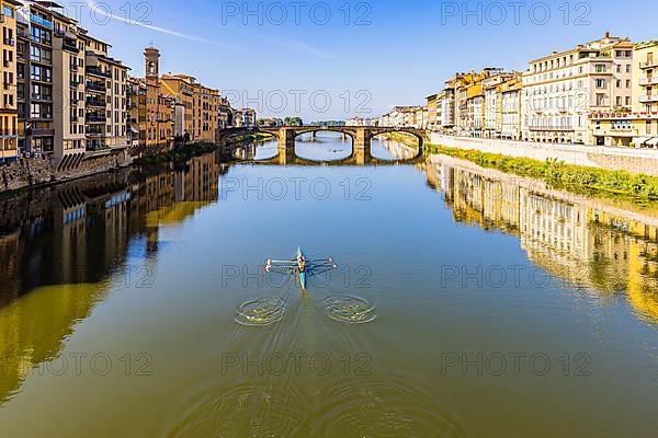 Rowers training on the river Arno, behind the Arno bridge Ponte S. Trinita