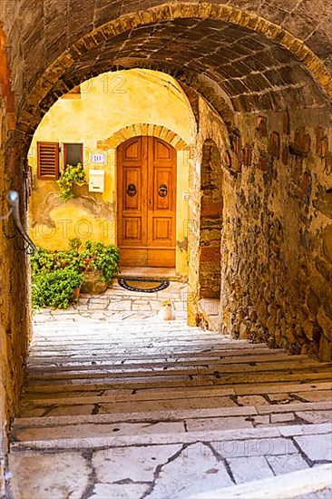 Arched passageway with view of a house entrance door, Petroio
