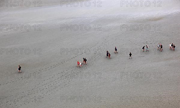 View of the walkers on the mudflats from the monastery hill of Mont Saint-Michel, Lower Normandy