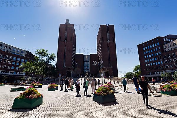Pedestrians in front of monumental city hall with two towers, north side in summer