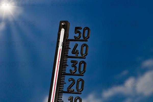 Symbolic image of the heat wave, thermometer at 45 degrees and sun rays