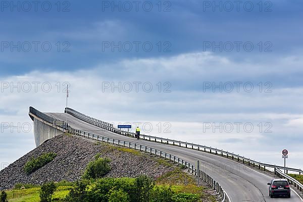 Cyclist and car on Atlantic Road, curvy bridge Storseisundbrua