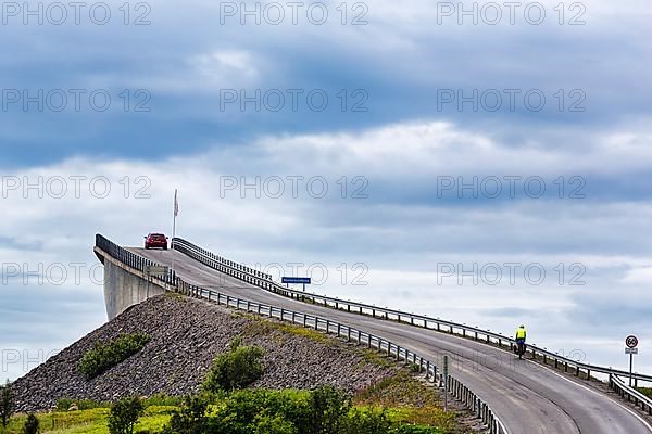 Cyclist and car on Atlantic Road, curvy bridge Storseisundbrua