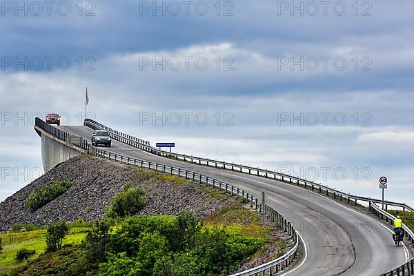 Cyclist and car on Atlantic Road, curvy bridge Storseisundbrua