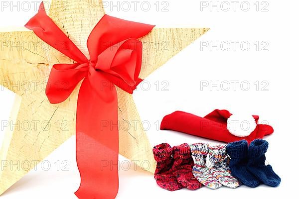 Christmas wooden star with a red bow isolated against a white background, Self-knitted socks on the side