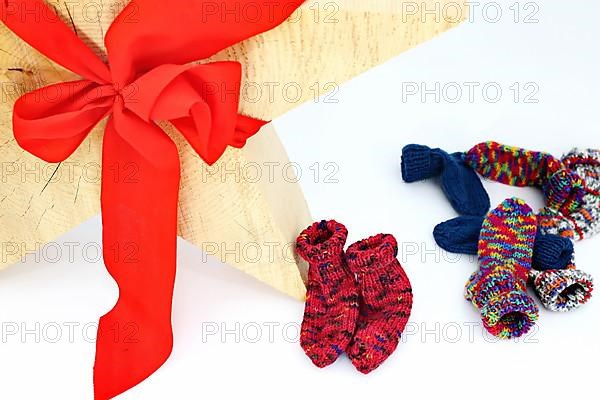 Christmas wooden star with a red bow isolated against a white background, Self-knitted socks on the side