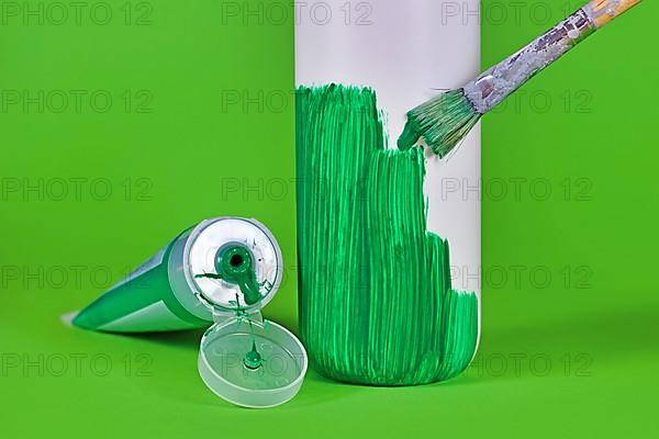 Concept for greenwashing with white plastic bottle being painted green,