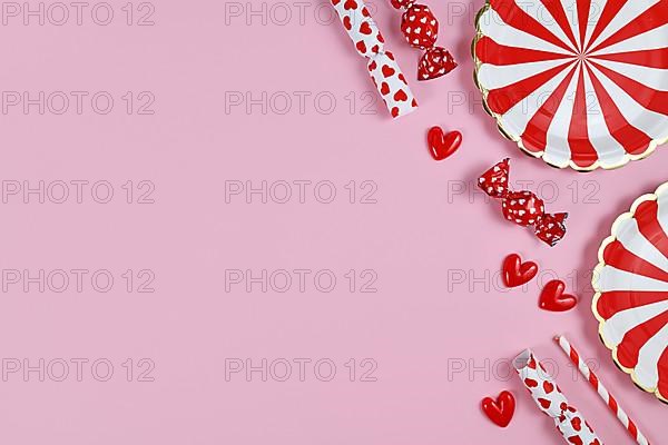 Party flat lay with red paper plates, heart ornaments