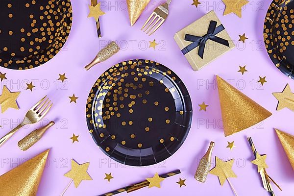 Party flat lay with black and golden plates, forks